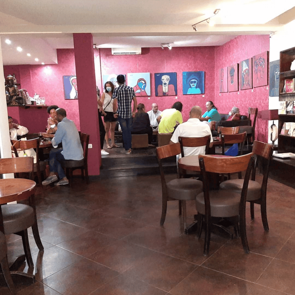 Bookshelves and paintings dot the room in this cafe. (Coffee Shops Cape Verde)