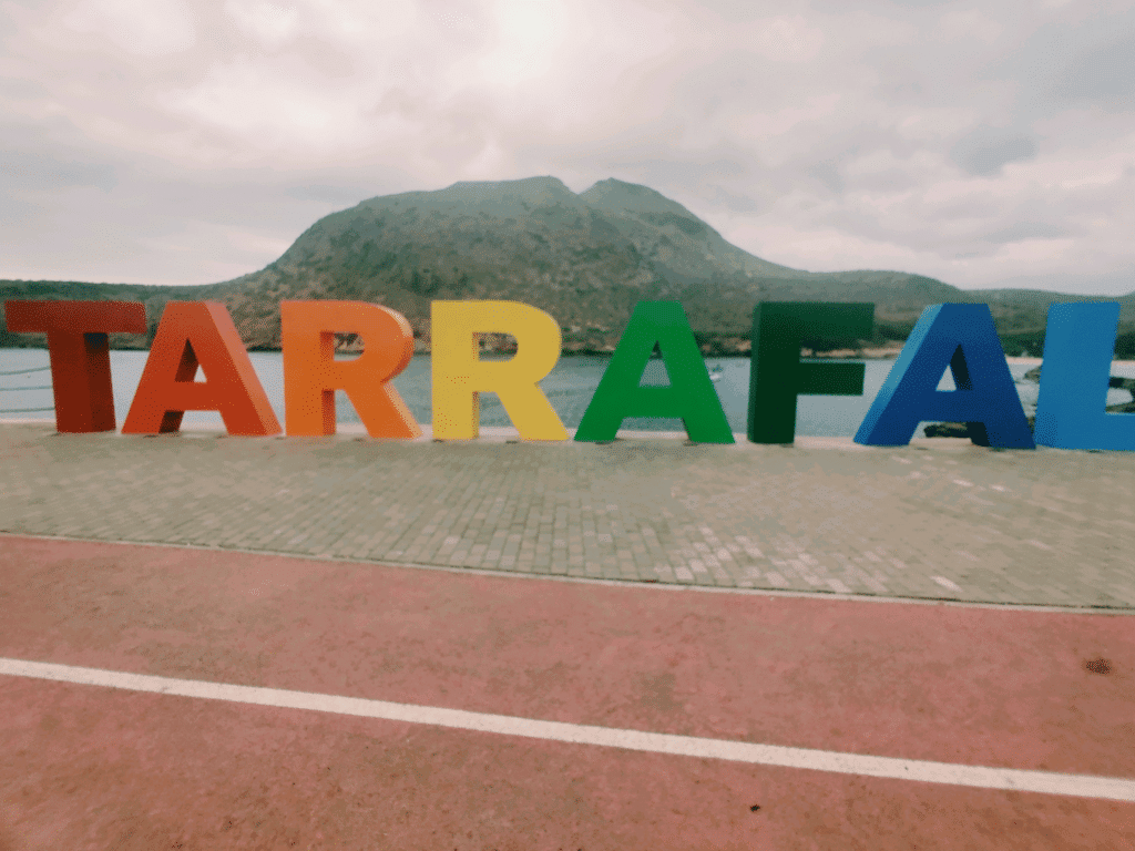 A colourful sign spelling "Tarrafal" lies on the coastline of Tarrafal.